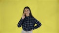 Happy woman standing isolated over yellow background while talking by phone Royalty Free Stock Photo