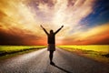 Happy woman standing on long road at sunset Royalty Free Stock Photo