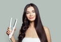 Happy woman with straight hair and curly hair using hair straightener. Cute girl straightening healthy brunette hairstyle Royalty Free Stock Photo