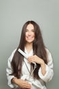 Happy woman straighten her hair on white background. Haircare concept Royalty Free Stock Photo