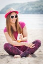 Happy woman in straw hat and sunglasses using sun lotion, sun protection on beach Royalty Free Stock Photo