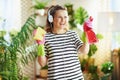 Happy woman in striped shirt in sunny day housecleaning