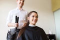 Happy woman with stylist making hairdo at salon Royalty Free Stock Photo