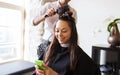 Happy woman with stylist making hairdo at salon Royalty Free Stock Photo