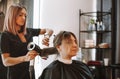 Happy woman with stylist making hairdo at salon Royalty Free Stock Photo