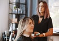 Happy woman with stylist making hairdo at salon Royalty Free Stock Photo