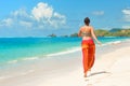 Happy woman in summer loose trousers running on tropical beach