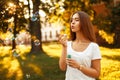 Happy woman with summer mood blowing soap bubbles in the park Royalty Free Stock Photo