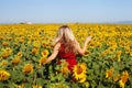 Happy woman in summer sunflower field enjoying life, red dress and yellow flowers Royalty Free Stock Photo