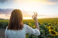 Happy woman in sunflower field. Summer girl in flower field cheerful. Asian Caucasian young woman raise arm OK and freedom show in Royalty Free Stock Photo