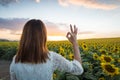 Happy woman in sunflower field. Summer girl in flower field cheerful. Asian Caucasian young woman raise arm OK and freedom show in Royalty Free Stock Photo