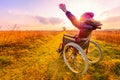 Happy woman at sunset. A young girl in a wheelchair Royalty Free Stock Photo