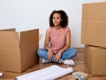 Happy woman surrounded by large boxes