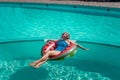 Happy woman in a swimsuit and sunglasses floating on an inflatable ring in the form of a watermelon, in the pool during