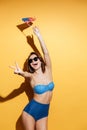 Happy woman in swimwear holding USA flag showing peace gesture. Royalty Free Stock Photo