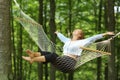 Happy woman swinging on hammock in a forest Royalty Free Stock Photo