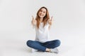 Happy woman in t-shirt sitting on the floor Royalty Free Stock Photo