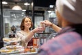 Happy woman taking coffee cup from seller at cafe Royalty Free Stock Photo