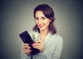 Happy young woman taking money out of her wallet isolated on gray background Royalty Free Stock Photo
