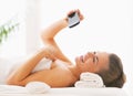 Happy woman taking self photo while laying on massage table Royalty Free Stock Photo