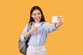 Happy woman taking selfie with phone on yellow background