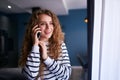 Happy woman talking on cellphone at living room. Portrait of cheerful female making a phone call while standing at the Royalty Free Stock Photo