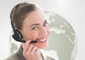 Happy woman talking on headset with globe in background Royalty Free Stock Photo