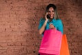 Happy woman talking on the phone with freshly made shopping bags Royalty Free Stock Photo