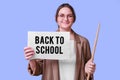 Happy woman teacher holds a sheet of paper with the text of the new variant of the covid virus Omicron on blue background Royalty Free Stock Photo