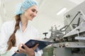 Happy woman technician checking quality of industrial machine