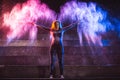 Happy woman throws color powder in shape of angel wings