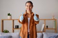 Happy woman, thumbs up and cleaning service with a smile in a house or apartment living room for safety with gloves Royalty Free Stock Photo