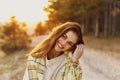 Happy woman tilted her head to the side in nature near coniferous trees in the forest