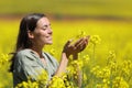 Happy woman touching and smelling flowers in a field Royalty Free Stock Photo