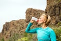 Happy woman trail runner drinking water in mountains Royalty Free Stock Photo