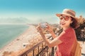 Woman travel blogger takes quality photos of the seacoast and Konyaalti beach in Antalya, Turkey