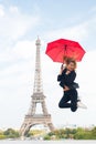 Happy woman travel in paris, france. Woman jump with fashion umbrella. Girl with beauty look at eiffel tower. Parisian Royalty Free Stock Photo