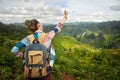 Happy woman traveler with backpack enjoying a beautiful view of