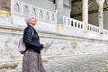 Happy woman traveler holding in her hands map and  looks beautiful view of Topkapi Palace, Istanbul, Turkey. Royalty Free Stock Photo