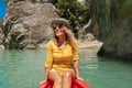 Happy woman traveler lifestyle sitting and enjoying on a red canoe in beautiful canyon with green water river - joyful free female