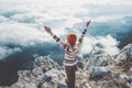 Happy woman traveler on mountain summit hands raised