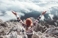 Happy woman traveler on mountain summit hands raised up