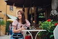 Happy woman traveler sitting in outdoors cafe in retro vintage city Royalty Free Stock Photo