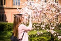 Happy woman traveler take photos by camera with cherry blossoms tree on vacation while spring Royalty Free Stock Photo