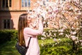 Happy woman traveler take photos by camera with cherry blossoms tree on vacation while spring Royalty Free Stock Photo