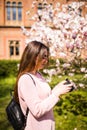 Happy woman traveler take photos by camera with cherry blossoms tree on vacation while spring Royalty Free Stock Photo