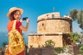 Woman traveler takes photos on her mobile phone of the sights of the Mediterranean part of Turkey. Ancient fortress tower Royalty Free Stock Photo