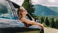 Happy woman travels by car in the mountains. Summer vacation concept Royalty Free Stock Photo