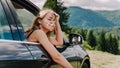 Happy woman travels by car in the mountains. Summer vacation concept Royalty Free Stock Photo