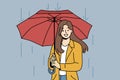 Happy woman with umbrella walks in rain along autumn street and looks at screen with wide smile